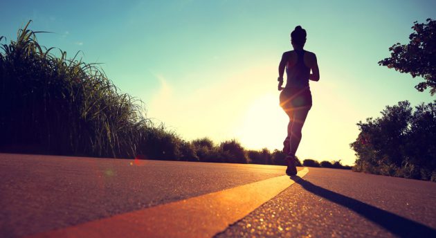 young fitness woman running on sunrise seaside trail